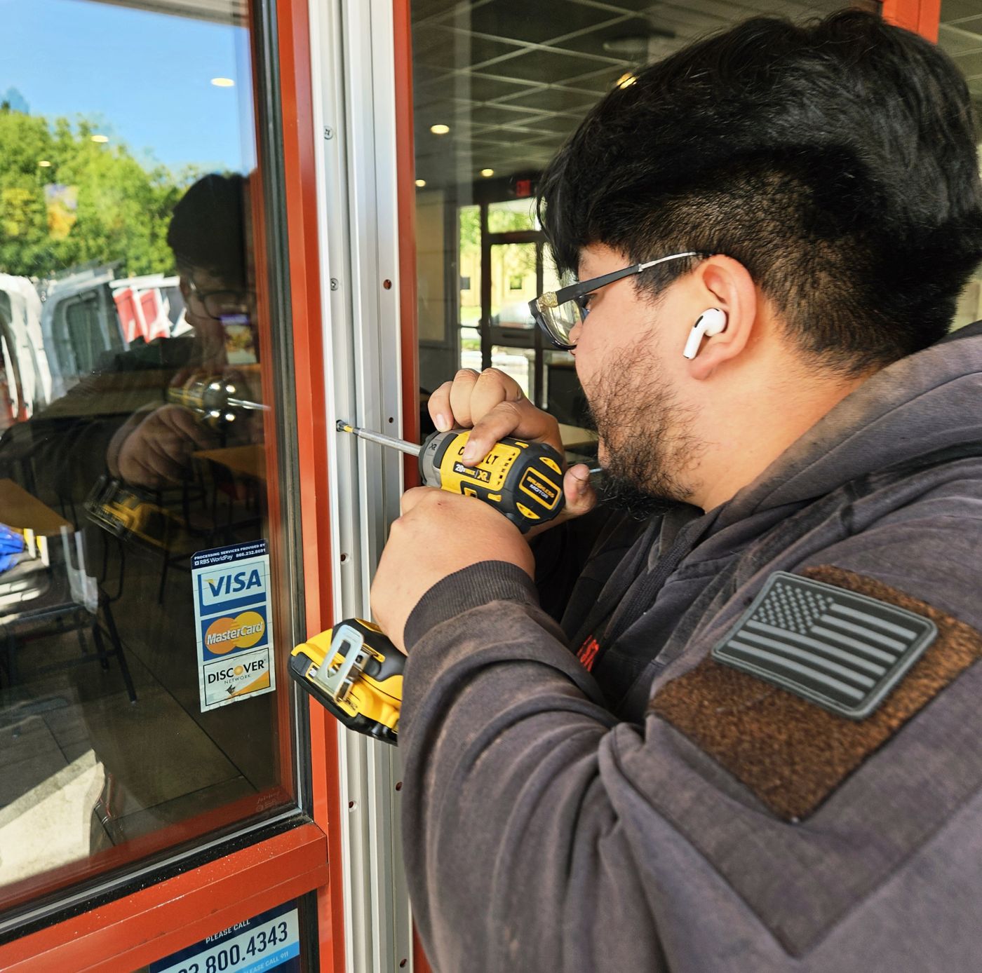 Lock Stop technician working on a storefront door lock