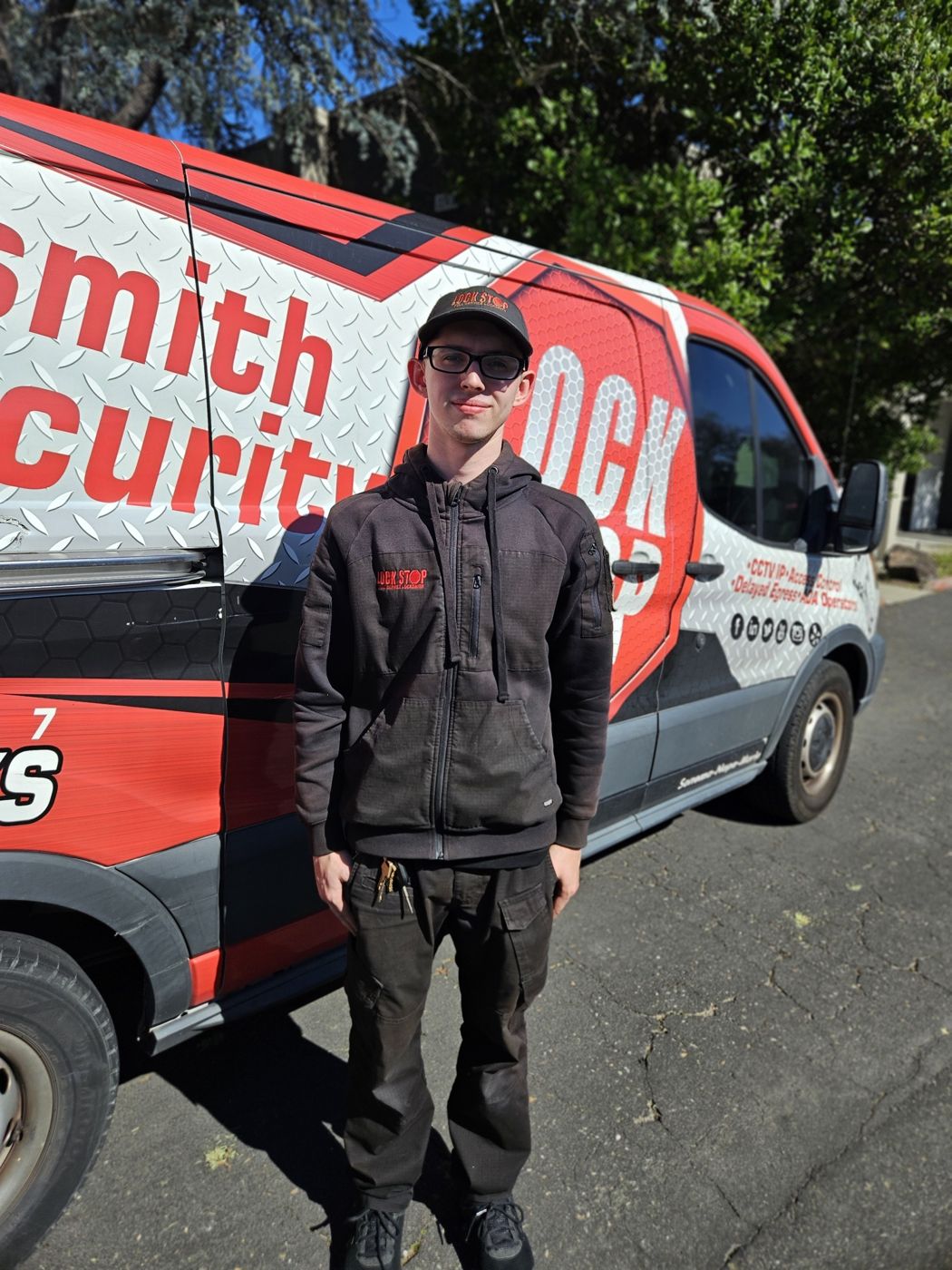 Lock Stop and Key technician standing beside the company van
